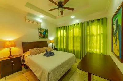 a bedroom with a bed and a ceiling fan at Villa Felicidad by Vacation Pura Vida in Esterillos
