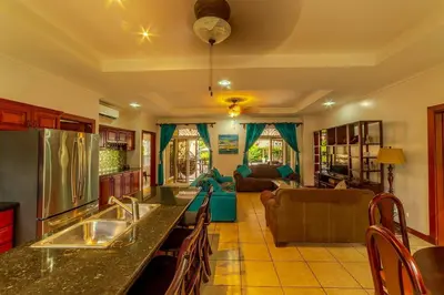 a kitchen and living room with a counter top at Villa Felicidad by Vacation Pura Vida in Esterillos