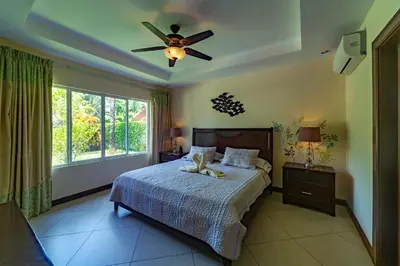 a bedroom with a bed and a ceiling fan at Villa Arrecife by Vacation Pura Vida in Bejuco