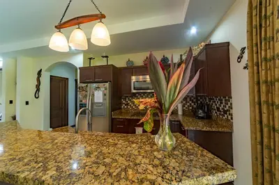a kitchen with a vase of flowers on a counter at Villa Arrecife by Vacation Pura Vida in Bejuco