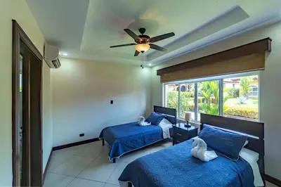 a bedroom with two beds and a ceiling fan at Villa Arrecife by Vacation Pura Vida in Bejuco