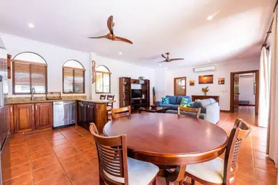 a kitchen and living room with a wooden table and chairs at Villa Escapadita by Vacation Pura Vida in Esterillos