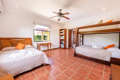 a bedroom with two beds and a ceiling fan at Villa Escapadita by Vacation Pura Vida in Esterillos