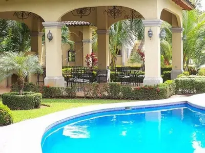 a house with a swimming pool in front of a house at Villa Escapadita by Vacation Pura Vida in Esterillos