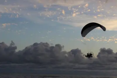 a person on a parachute flying over the ocean at Villa Escapadita by Vacation Pura Vida in Esterillos