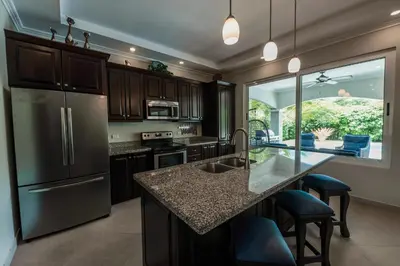 a kitchen with a stainless steel refrigerator and a counter at Casa 40 Villa Mario by Vacation Pura Vida in Bejuco