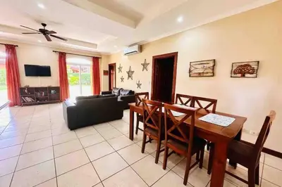 a living room with a dining room table and a couch at Villa Tranquilidad by Vacation Pura Vida in Esterillos