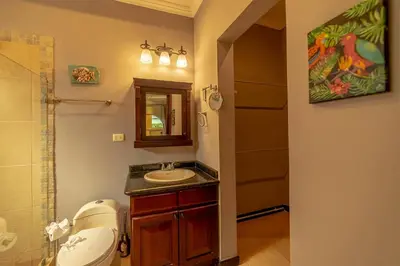 a bathroom with a sink and a toilet and a mirror at Villa Estrella de Mar by Vacation Pura Vida in Bejuco