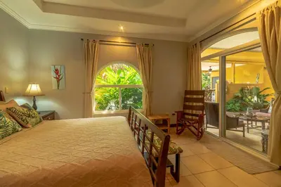a bedroom with a large bed and a dining room at Villa Estrella de Mar by Vacation Pura Vida in Bejuco