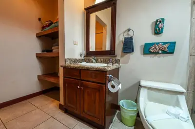 a bathroom with a sink and a toilet and a mirror at Villa Zen by Vacation Pura Vida in Esterillos