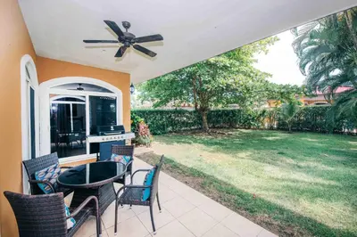 a patio with a table and chairs and a backyard at Villa Zen by Vacation Pura Vida in Esterillos