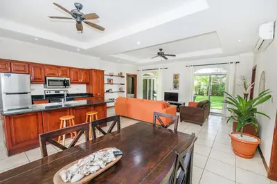 a kitchen and living room with a table at Villa Zen by Vacation Pura Vida in Esterillos