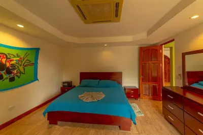 a bedroom with a bed with a blue comforter at Villa Macaw by Vacation Pura Vida in Esterillos Este