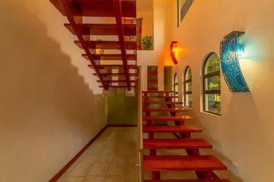a staircase in a room with a stair case at Villa Macaw by Vacation Pura Vida in Esterillos Este