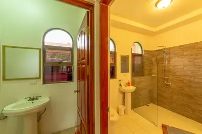 a bathroom with a toilet sink and a shower at Villa Macaw by Vacation Pura Vida in Esterillos Este