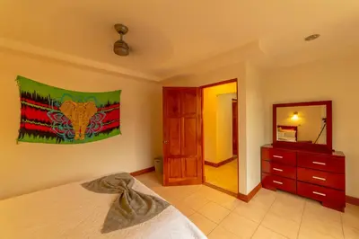 a bedroom with a bed and a dresser and a mirror at Villa Macaw by Vacation Pura Vida in Esterillos Este