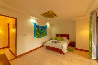 a bedroom with a bed and a painting on the wall at Villa Macaw by Vacation Pura Vida in Esterillos Este