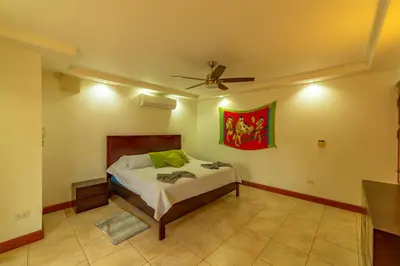 a bedroom with a bed and a ceiling fan at Villa Macaw by Vacation Pura Vida in Esterillos Este