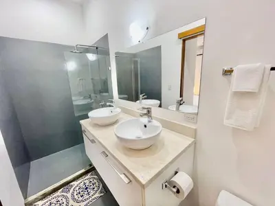 a white bathroom with two sinks and a shower at Modern 2 Bed 2 Bath l Strong Wifi Carport in Jacó