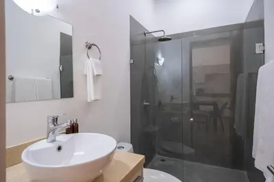 a white bathroom with a sink and a shower at Carport Strong Wifi Vaulted Ceilings in Jacó