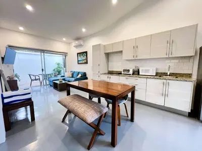 a kitchen and living room with a wooden table and chairs at Carport Strong Wifi Vaulted Ceilings in Jacó