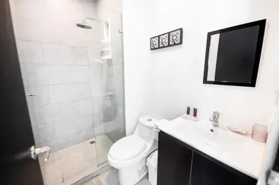 a bathroom with a toilet and a sink and a shower at The Wavefront Beachfront Condo in Bejuco in Bejuco
