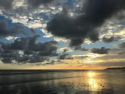a sunset on the beach with clouds in the sky at The Wavefront Beachfront Condo in Bejuco in Bejuco