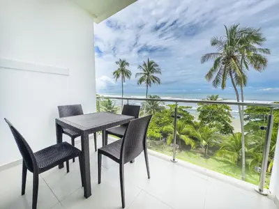 a balcony with a table and chairs and a view of the ocean at The Wavefront Beachfront Condo in Bejuco in Bejuco