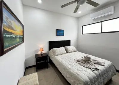 a white bedroom with a bed and a window at Spacious 2 Bed 2 Bath l Great Walking Score in Jacó