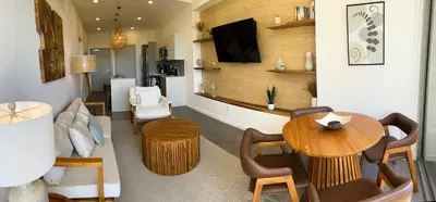a living room with a table and a tv at Sunset Family Package Units 304 & 305 in Jacó