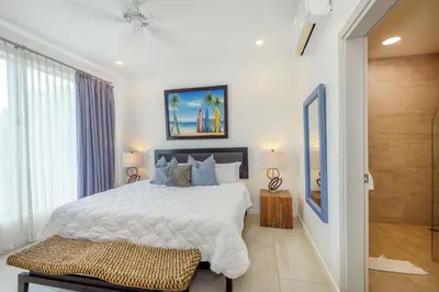 a bedroom with a large bed and a bathroom at Sunset Family Package Units 304 & 305 in Jacó