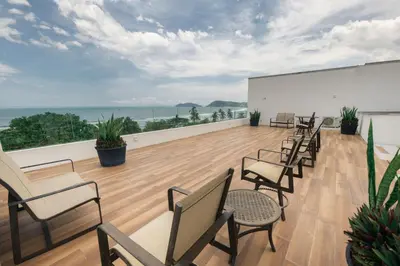 a room with chairs and a white wall and the ocean at Sunset Family Package Units 304 & 305 in Jacó