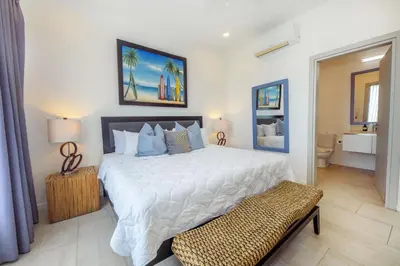 a bedroom with a large white bed and a bathroom at Sunset Family Package Units 304 & 305 in Jacó
