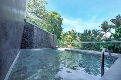 a swimming pool with a waterfall in a backyard at Sunset Family Package Units 304 & 305 in Jacó