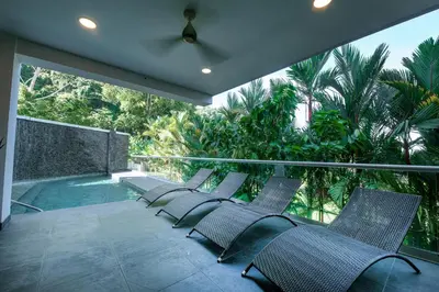 a row of chairs on a balcony with a swimming pool at Sunset Family Package Units 304 & 305 in Jacó