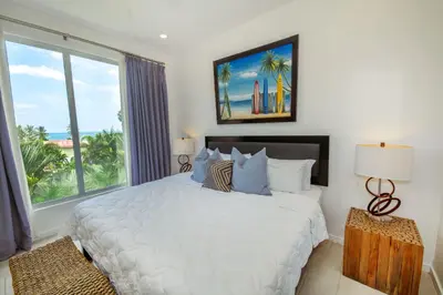 a bedroom with a bed and a large window at Sunset Family Package Units 304 & 305 in Jacó