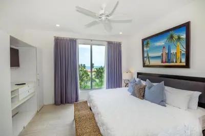 a bedroom with a bed and a large window at Ocean Views l Steps to Beach l Sunset 305 in Jacó