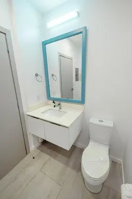 a bathroom with a white toilet and a mirror at Ocean Views l Steps to Beach l Sunset 305 in Jacó