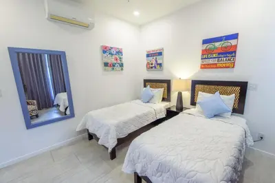 a bedroom with two beds and a mirror at Ocean Views l Steps to Beach l Sunset 305 in Jacó