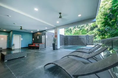 a living room with chairs and a couch on a balcony at Ocean Views l Steps to Beach l Sunset 305 in Jacó