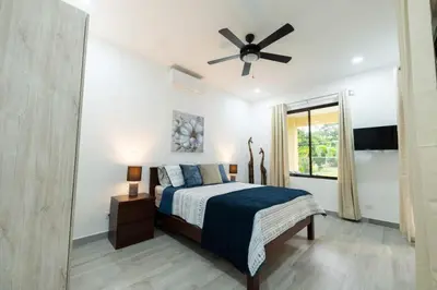 a bedroom with a bed and a ceiling fan at Villa Alegría de vivir by Vacation Pura Vida in Bejuco