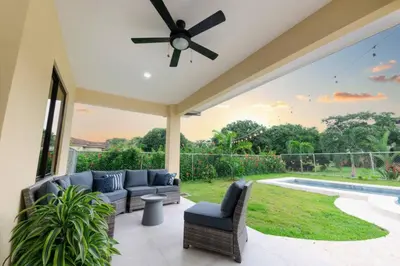 a patio with couches and a ceiling fan at Villa Alegría de vivir by Vacation Pura Vida in Bejuco
