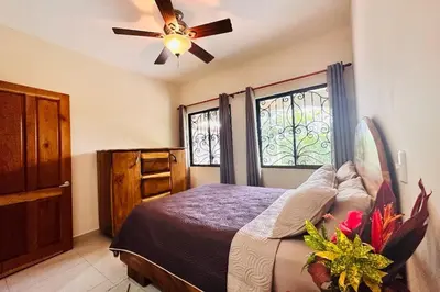 a bedroom with a bed and a ceiling fan at Villa Camino Corral by Vacation Pura Vida in Esterillos