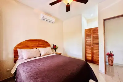 a bedroom with a large bed and a ceiling fan at Villa Camino Corral by Vacation Pura Vida in Esterillos