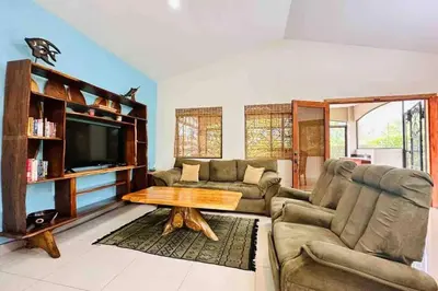 a living room with a couch and a table at Villa Camino Corral by Vacation Pura Vida in Esterillos