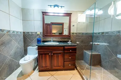 a bathroom with a sink and a toilet and a mirror at Villa Encanto by Vacation Pura Vida in Bejuco