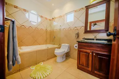 a bathroom with a tub and a toilet and a sink at Villa Encanto by Vacation Pura Vida in Bejuco