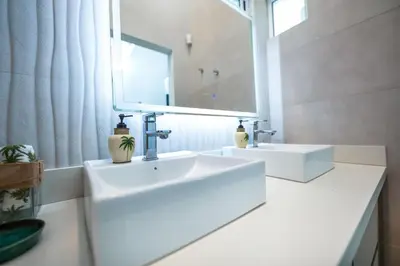 a white bathroom with a sink and a mirror at Villa Luna Nueva by Vacation Pura Vida in Esterillos