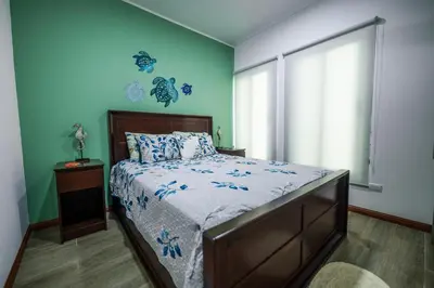 a bedroom with a bed with a blue wall at Villa Luna Nueva by Vacation Pura Vida in Esterillos