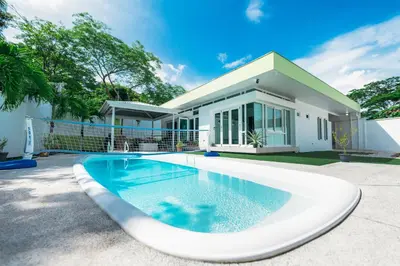 a swimming pool in front of a house at Villa Luna Nueva by Vacation Pura Vida in Esterillos